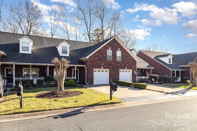 view of front of home with a garage, covered porch, and a front yard