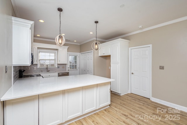 kitchen with appliances with stainless steel finishes, backsplash, white cabinets, kitchen peninsula, and light wood-type flooring