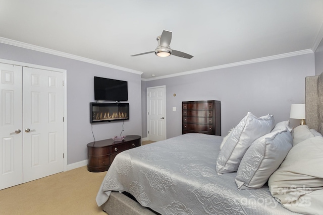 carpeted bedroom with ornamental molding, ceiling fan, and a closet