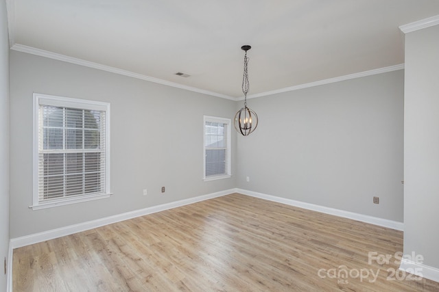 empty room with ornamental molding, a chandelier, and light hardwood / wood-style floors