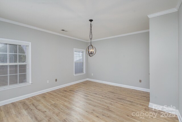 unfurnished room with crown molding, a chandelier, and light hardwood / wood-style floors