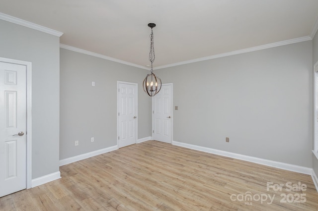 spare room with crown molding, light hardwood / wood-style floors, and a notable chandelier