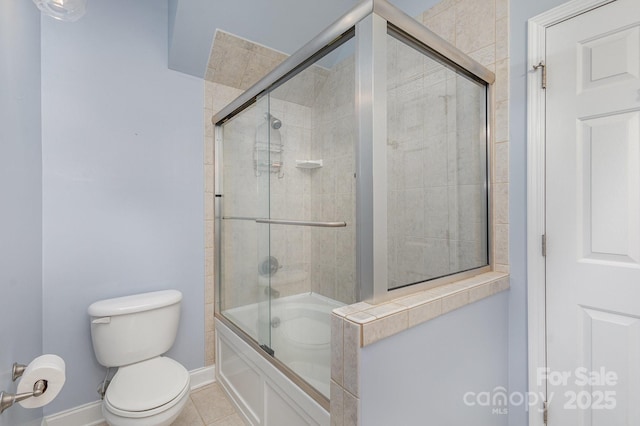 bathroom featuring tile patterned floors, combined bath / shower with glass door, and toilet