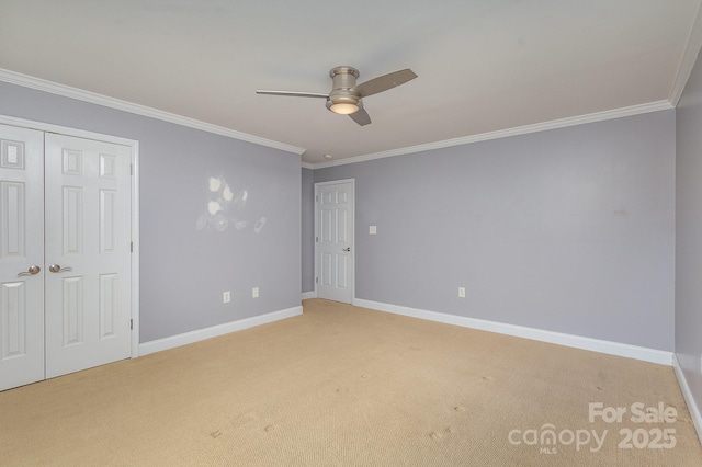 unfurnished bedroom with crown molding, carpet floors, a closet, and ceiling fan