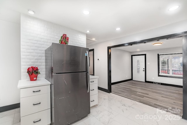 kitchen featuring white cabinetry and stainless steel fridge