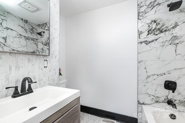 bathroom featuring tiled shower / bath combo and vanity