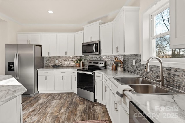 kitchen featuring a sink, ornamental molding, white cabinetry, and stainless steel appliances