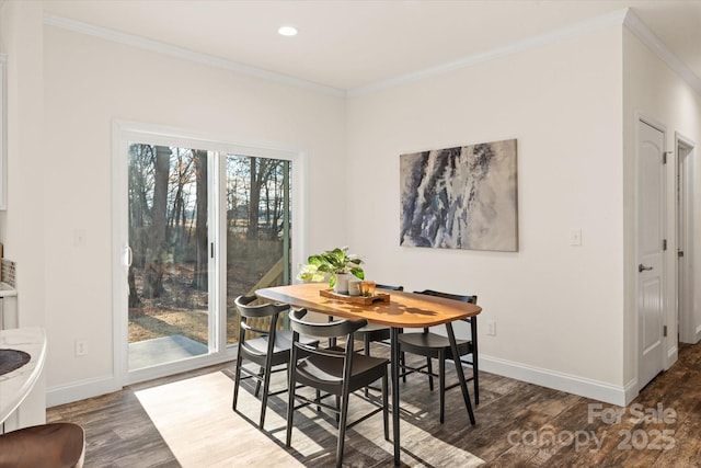 dining area with wood finished floors, baseboards, and ornamental molding