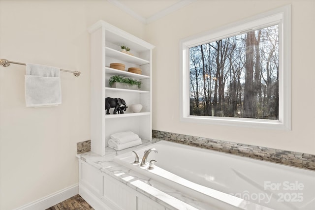 full bathroom featuring a garden tub, crown molding, and baseboards