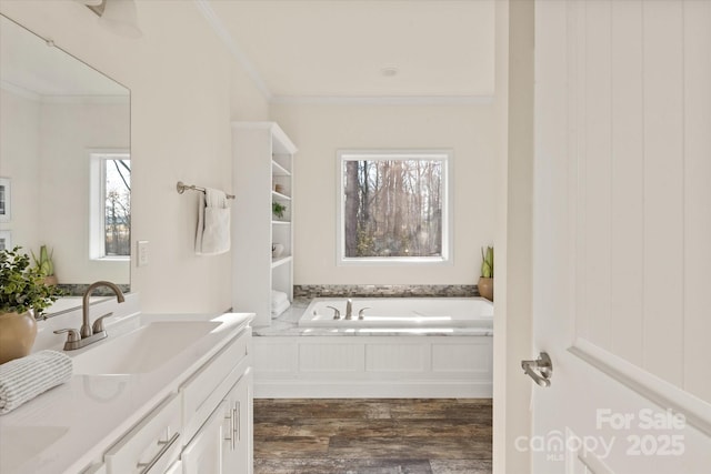 full bathroom with a garden tub, ornamental molding, a sink, wood finished floors, and double vanity