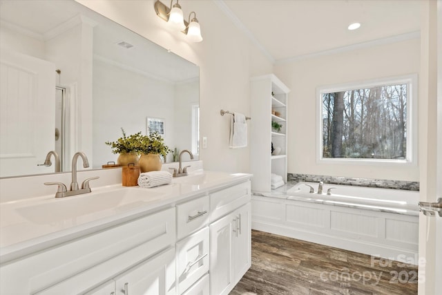 full bathroom with crown molding, wood finished floors, double vanity, and a sink