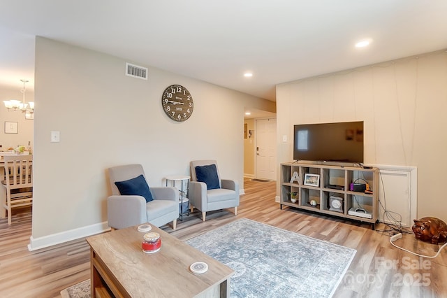 living room featuring a notable chandelier and wood-type flooring