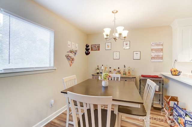 dining room with light hardwood / wood-style floors and a chandelier