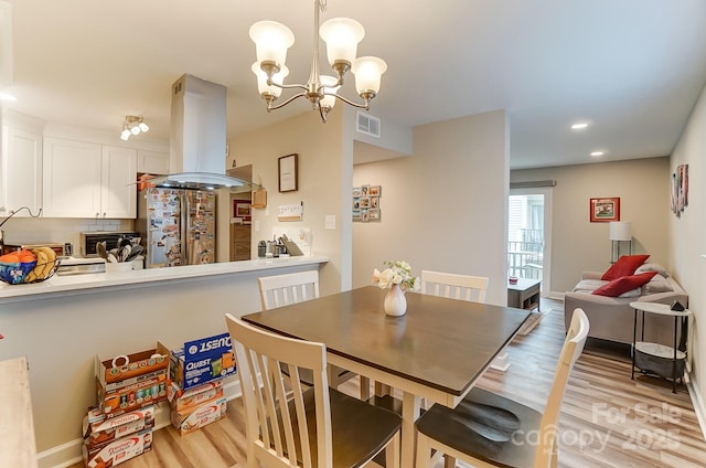 dining room with a chandelier and light wood-type flooring