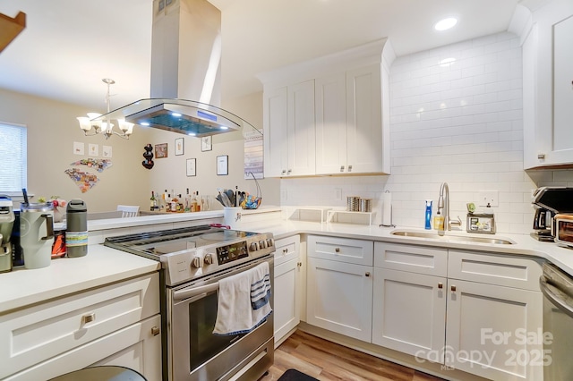 kitchen with sink, white cabinetry, tasteful backsplash, island range hood, and stainless steel appliances