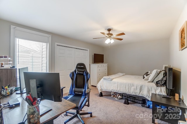 carpeted bedroom featuring a closet and ceiling fan