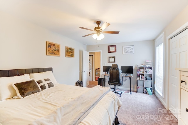 carpeted bedroom featuring stacked washer and clothes dryer and ceiling fan