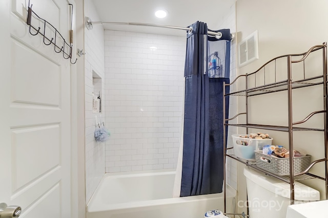 bathroom featuring shower / bathtub combination with curtain and toilet