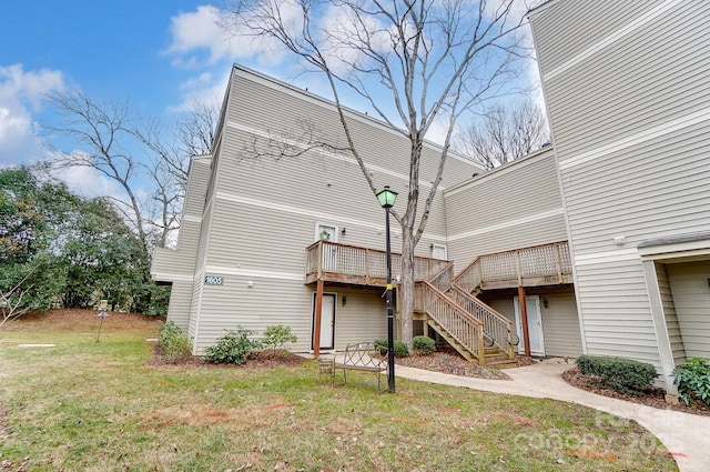 back of house featuring a wooden deck and a yard