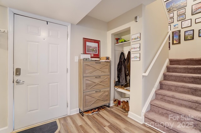 mudroom featuring built in shelves and light hardwood / wood-style flooring