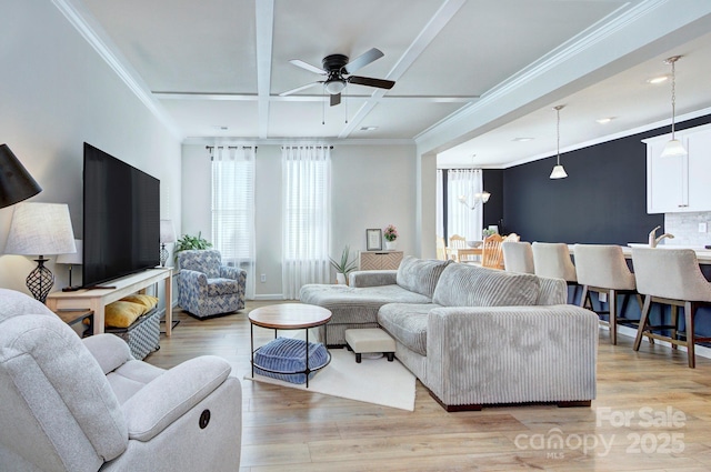 living room with beam ceiling, coffered ceiling, ornamental molding, light hardwood / wood-style floors, and ceiling fan with notable chandelier