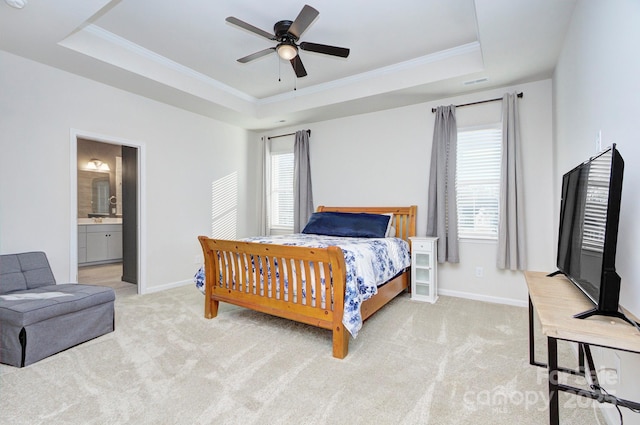 carpeted bedroom featuring ornamental molding, a raised ceiling, ceiling fan, and ensuite bathroom