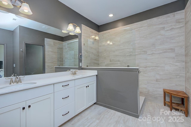 bathroom with vanity and tiled shower