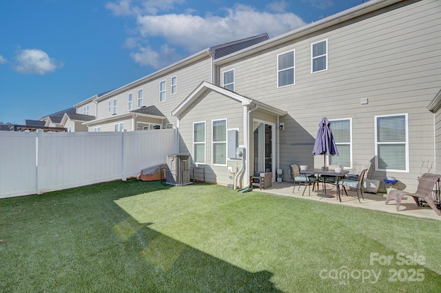 rear view of property with a patio and a lawn