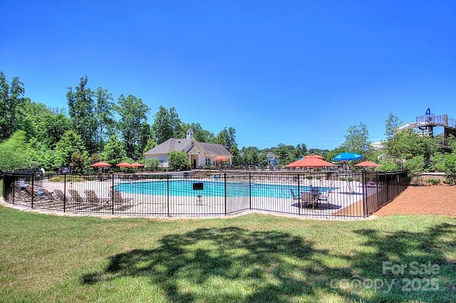 view of pool with a patio and a lawn