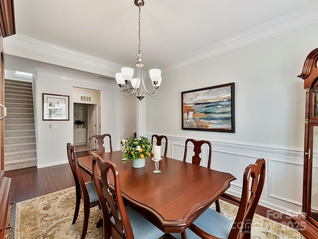 dining area with ornamental molding, dark hardwood / wood-style flooring, and a chandelier