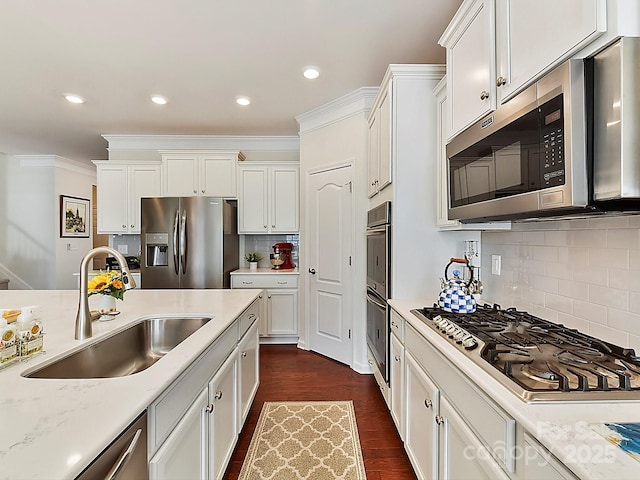 kitchen with appliances with stainless steel finishes, sink, white cabinets, and dark hardwood / wood-style floors