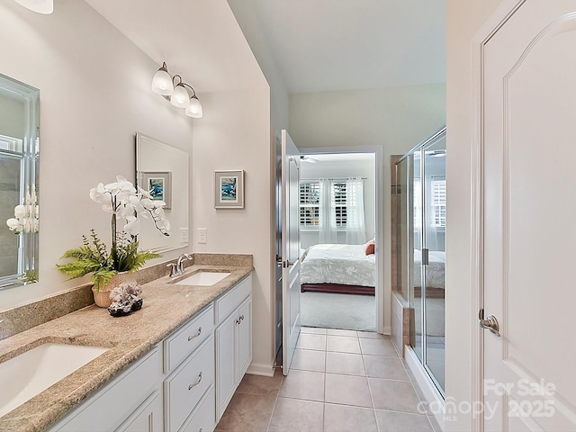 bathroom with tile patterned floors, a shower with door, and vanity