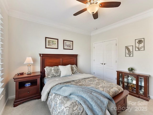 carpeted bedroom with crown molding, a closet, and ceiling fan