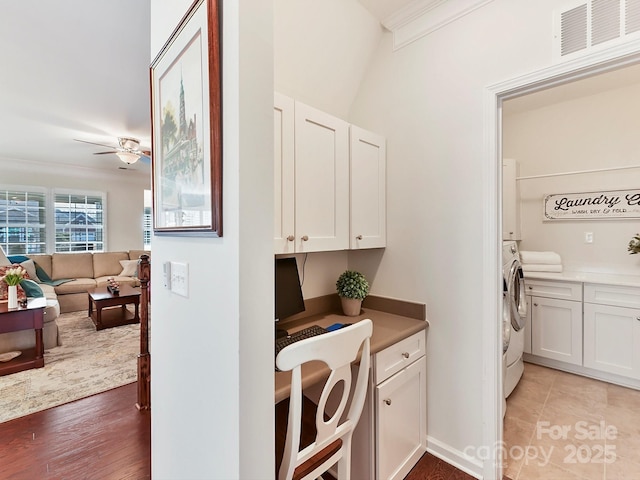 laundry area with ceiling fan, cabinets, light hardwood / wood-style floors, ornamental molding, and washer / clothes dryer