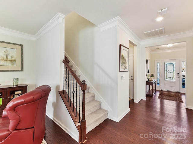 entrance foyer with ornamental molding and dark hardwood / wood-style floors