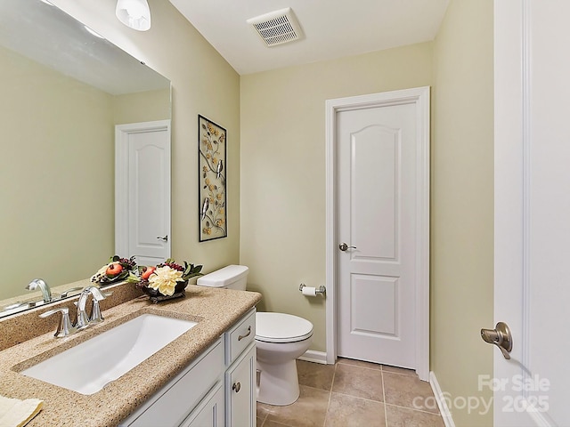 bathroom with tile patterned flooring, vanity, and toilet