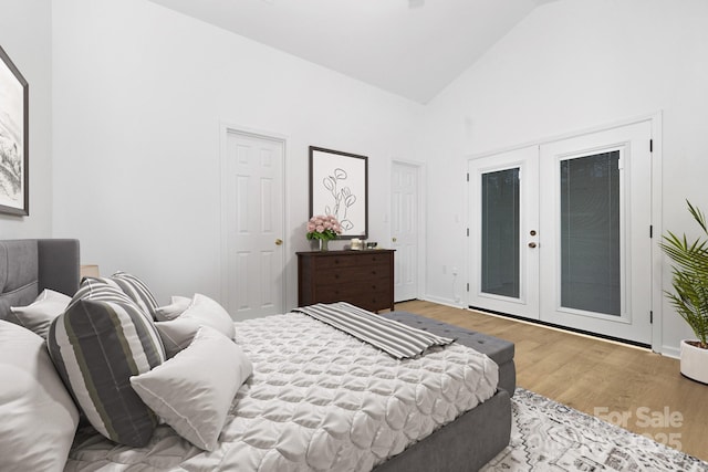 bedroom with light hardwood / wood-style flooring, access to exterior, high vaulted ceiling, and french doors