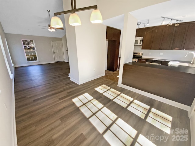 kitchen with sink, dark hardwood / wood-style flooring, stainless steel range with electric stovetop, ceiling fan, and dark brown cabinetry