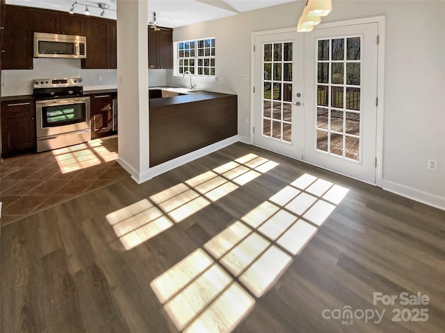 kitchen with stainless steel appliances, dark brown cabinets, and dark hardwood / wood-style floors