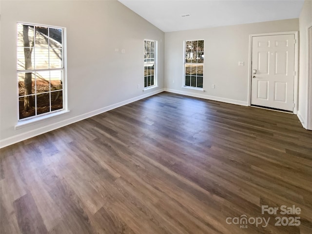 unfurnished room with vaulted ceiling and dark hardwood / wood-style floors