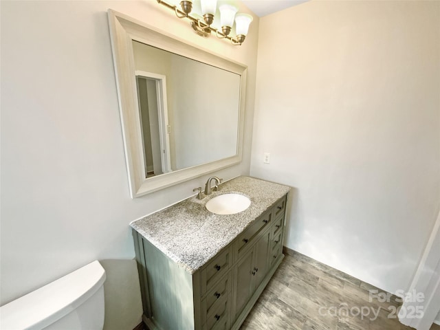 bathroom featuring hardwood / wood-style flooring, vanity, and toilet