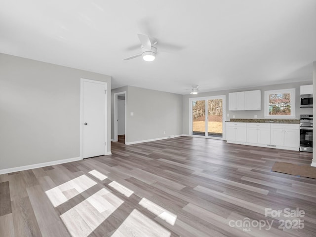 unfurnished living room featuring light hardwood / wood-style floors and ceiling fan