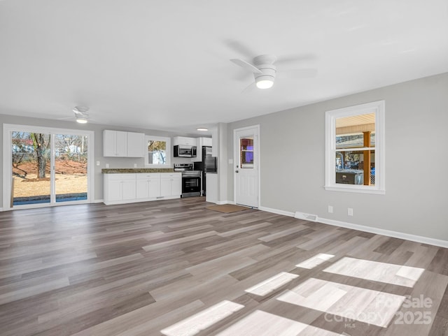 unfurnished living room featuring ceiling fan and light hardwood / wood-style floors