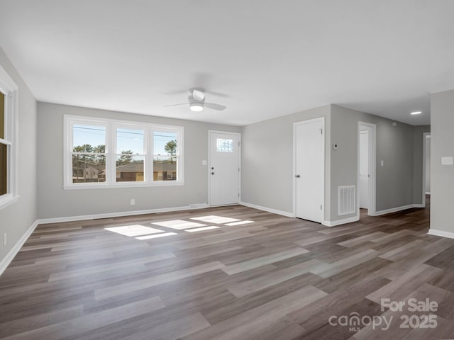 unfurnished living room featuring ceiling fan and hardwood / wood-style floors