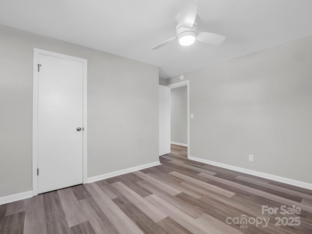 empty room with ceiling fan and light hardwood / wood-style floors