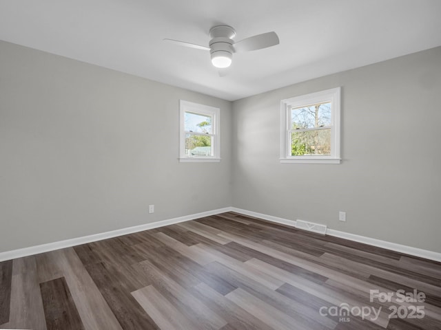 unfurnished room featuring wood-type flooring, a wealth of natural light, and ceiling fan