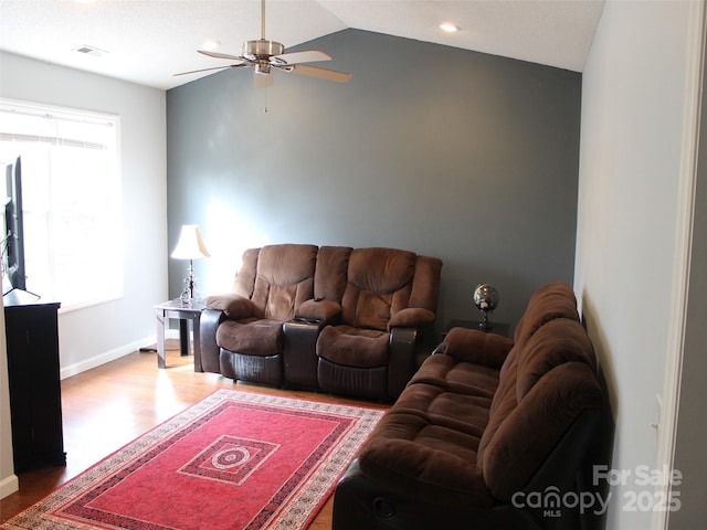 living room with lofted ceiling, hardwood / wood-style flooring, and ceiling fan