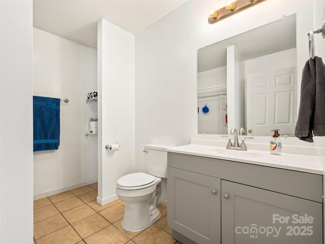 bathroom with vanity, a textured ceiling, tile patterned floors, and toilet