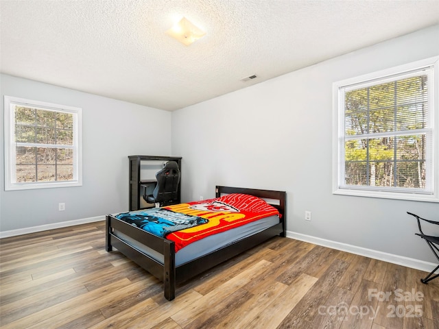 bedroom featuring wood-type flooring and a textured ceiling