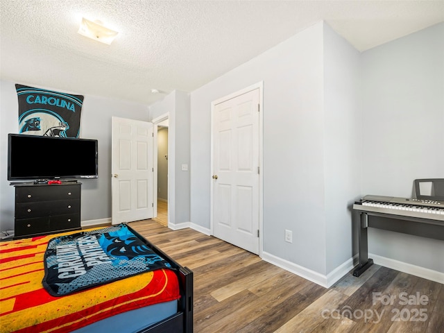 bedroom featuring wood-type flooring and a textured ceiling